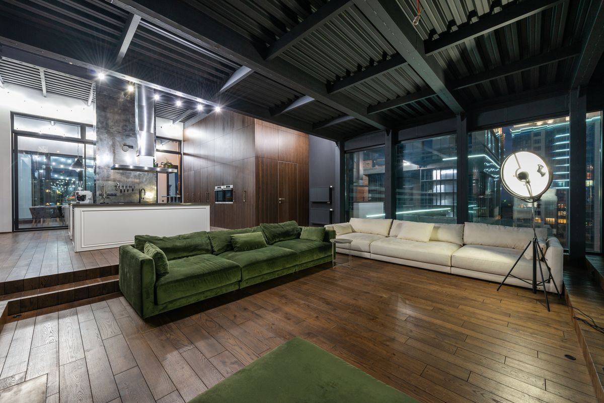Living room of a modern apartment with panoramic windows in the evening